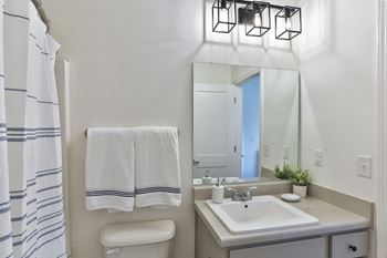 A white bathroom with a towel hanging on the wall.